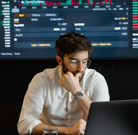 A man sitting in front of a computer working on a code.